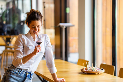 Woman looking at camera while sitting on table