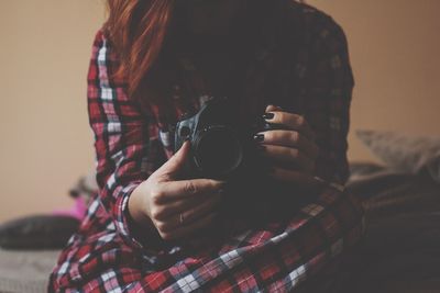 Close-up of hand holding camera at home