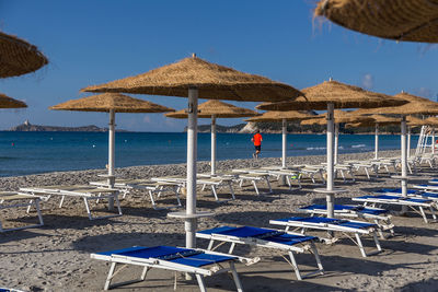 Deck chairs on beach against clear sky