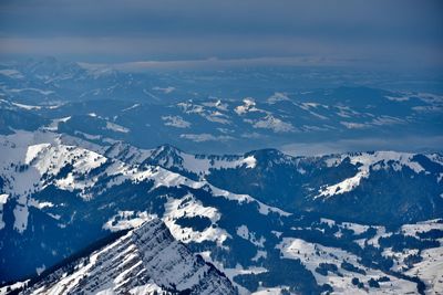 Aerial view of snowcapped mountains against sky