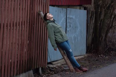 Portrait of woman leaning against fence