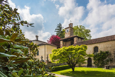 Low angle view of trees and building against sky