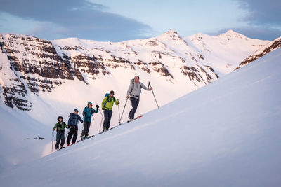 Group backcountry skiing in iceland with mountains