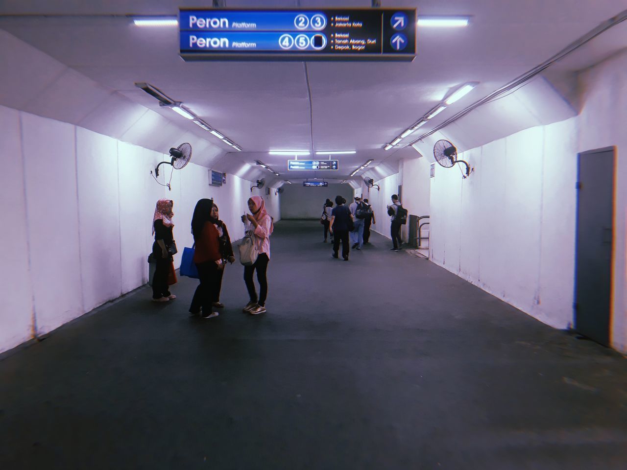 GROUP OF PEOPLE WALKING IN SUBWAY STATION