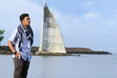 Young man standing against sky