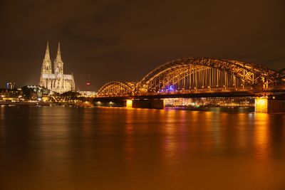 Illuminated hohenzollern bridge over city at night