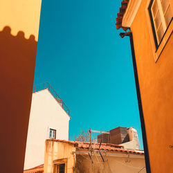 Low angle view of buildings against clear blue sky