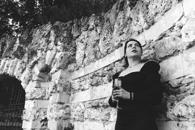 Low angle view of woman standing against wall