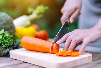 Cropped image of person preparing food on cutting board