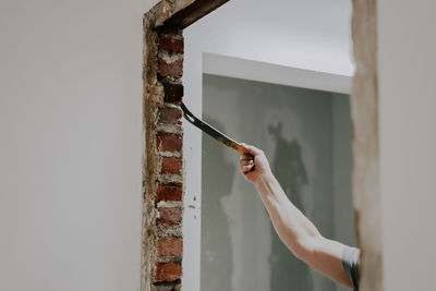 A man working with a crowbar in a doorway.