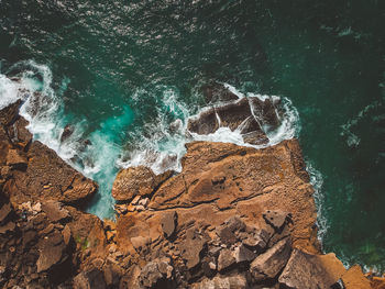 Directly above shot of rock formations by sea