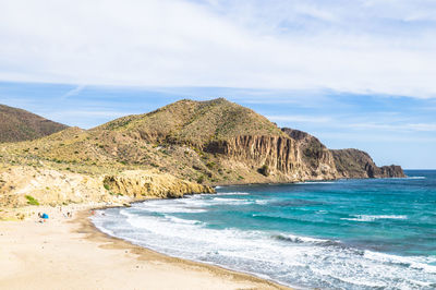 Scenic view of sea and mountains against sky