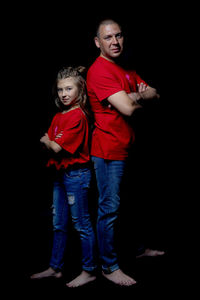 Full length of friends standing against black background