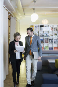 Mature businesswoman and businessman with paperwork in creative office