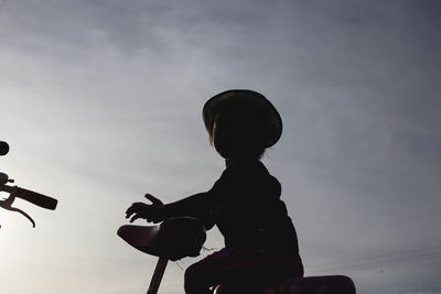 Silhouette boy playing against sky