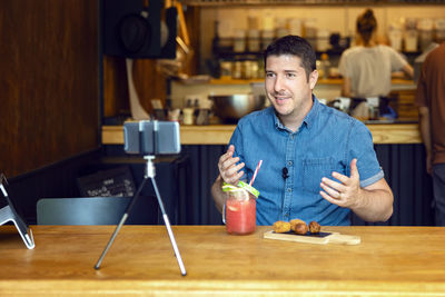 Portrait of smiling man with fruits on table