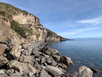 Scenic view of rocks on beach against sky