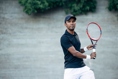 Midsection of man playing tennis