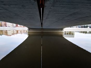 Reflection of bridge on river against building