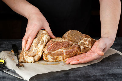 Close-up of man preparing food against black background