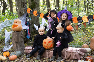 Happy kids in halloween costumes having fun in halloween decorations outdoor