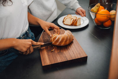 Midsection of woman preparing food on cutting board