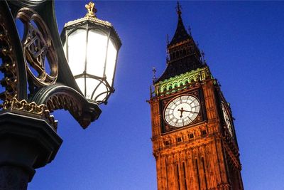 Low angle view of clock tower against blue sky