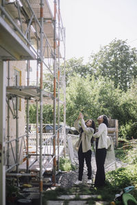 Female client standing with architect near under construction apartment