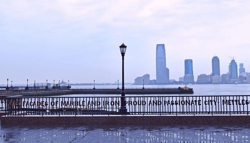 Promenade in hudson river by city against sky