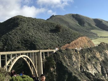 Arch bridge over mountains against sky