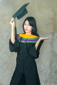 Portrait of woman standing against wall