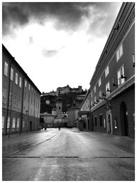 View of city street against cloudy sky