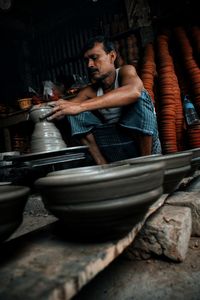 Low angle view of man making pottery in workshop