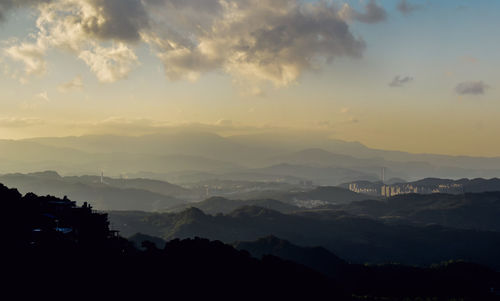 Scenic view of silhouette mountains against sky at sunset