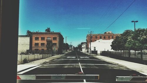 Empty road along buildings