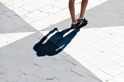Low section of woman walking on footpath