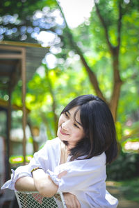 Young woman wearing sunglasses against plants