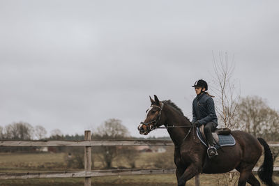 View of girl horseback riding