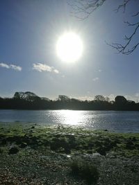 Scenic view of lake against bright sun