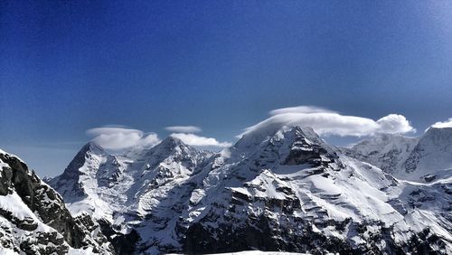 Scenic view of mountains against blue sky