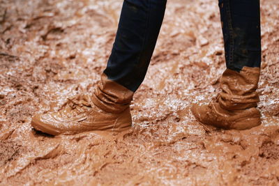 Low section of man standing on mud