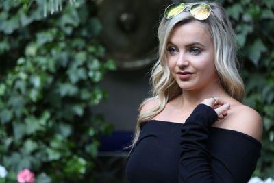 Portrait of beautiful woman standing against plants