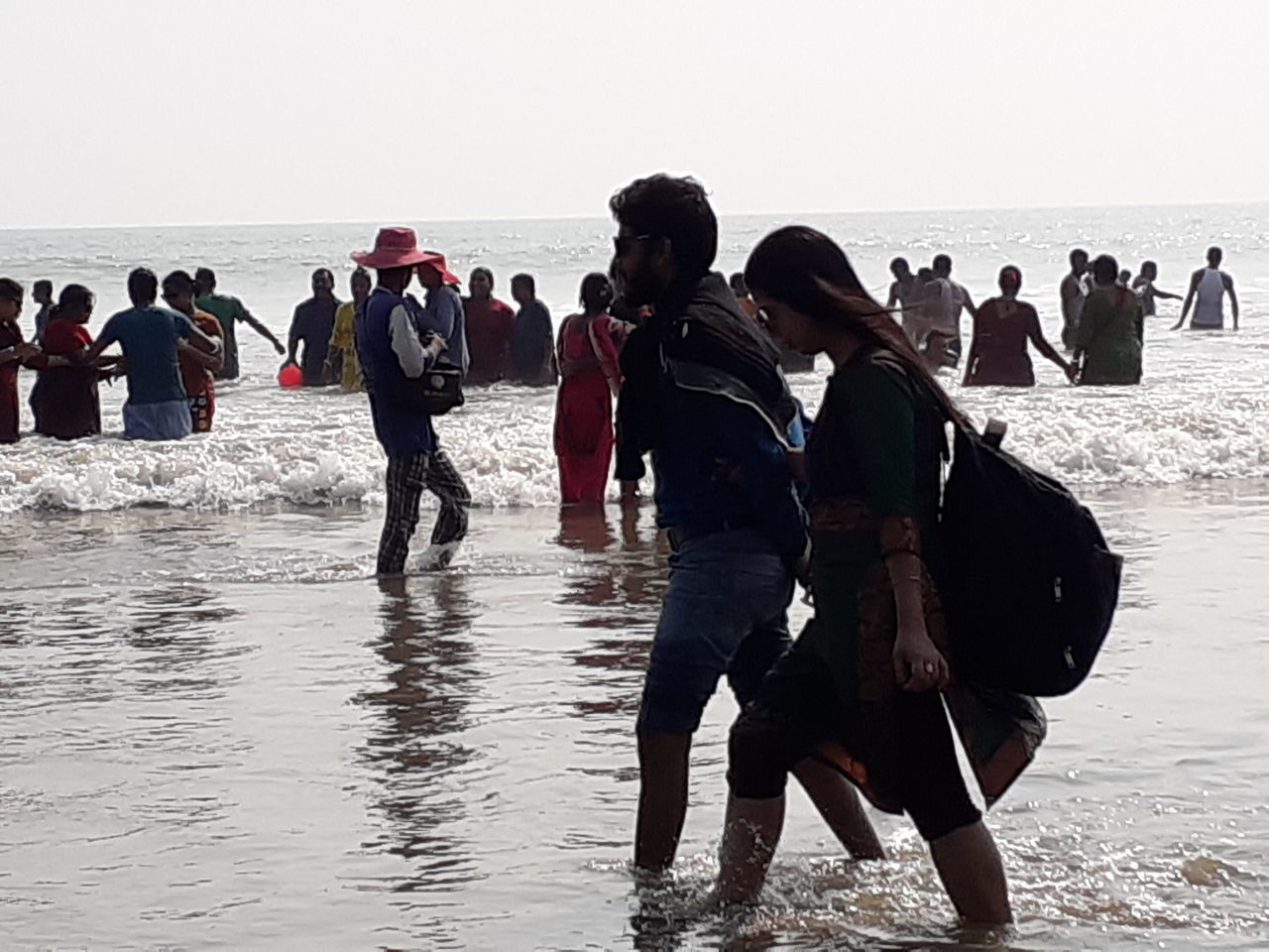 GROUP OF PEOPLE ON BEACH AGAINST CLEAR SKY