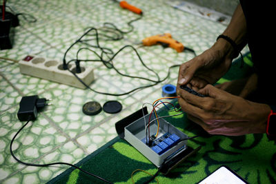 Midsection of person repairing electrical equipment