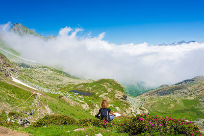 Rear view of woman in mountains against sky