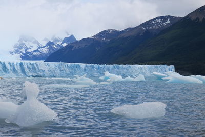 Scenic view of snowcapped mountains and sea against sky