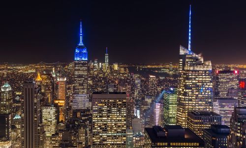 Illuminated cityscape against sky at night