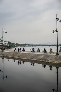 People walking on lake against sky