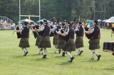Rear view of bagpipers on grassland