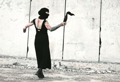 Full length of woman standing against wall